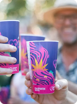 Custom Reusable Cups tile overlayed on a photo of People holding colourful custom printed cups at an outdoor festival event with the text 'custom reusable cups' and 'click here for more info' overlaid.