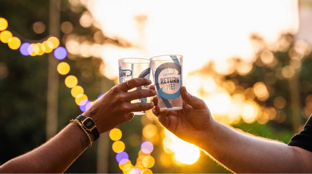 People holding custom bettercup tumbler at an outdoor event