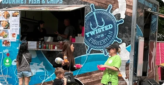 Stakeholders holding pink betterdish in front of Twisted Fisherman stall at the Moomba Festival 2026