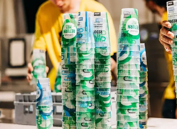 Reusable cups in use at a major festival with high turn over, hundreds of reusable bettercup custom branded and printed in stacks upside down ready for washing on site.