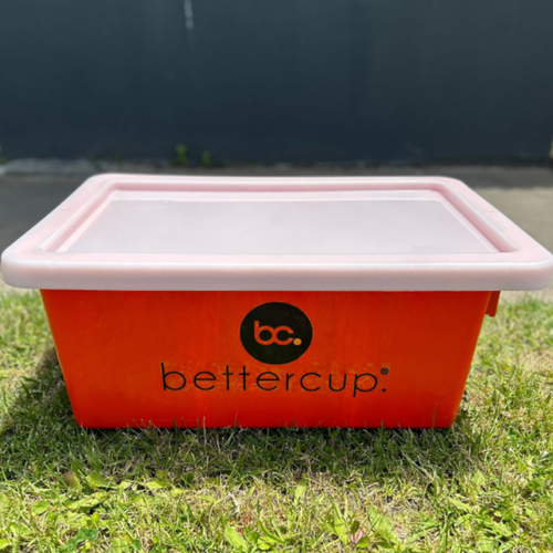 Orange tub with white lid and black bettercup brand sticker on the side, used for collecting and transporting reusable products around site at festivals and events in Australia.