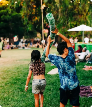 children at a festival carrying a large stack of reusable cups to get the deposit return in Australia