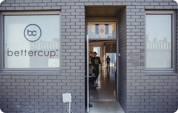 External photo of bettercup's factory where they manufacture and wash reusable products in Melbourne, Australia. The front door is open and staff members can be seen inside wearing bettercup branded tshirts.