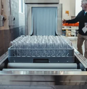 Reusable stemless bettercups being washed in a commercial dishwasher rack.